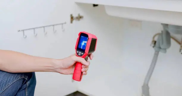Home consultant checking an interior wall for moisture with a digital meter